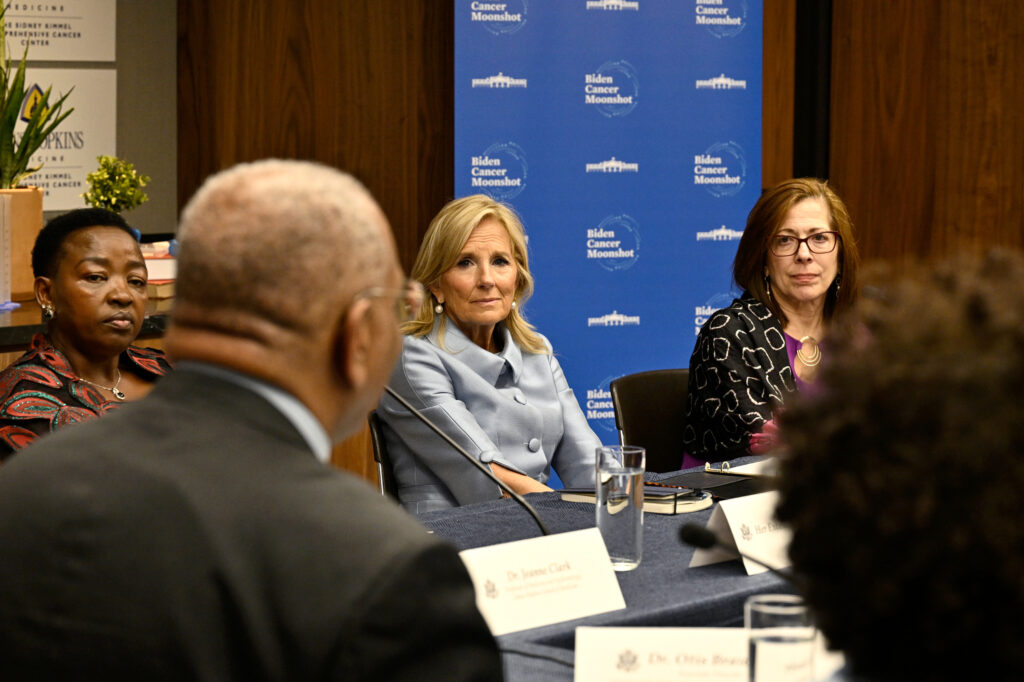 A group of people, including First Lady Jill Biden, sit around a table