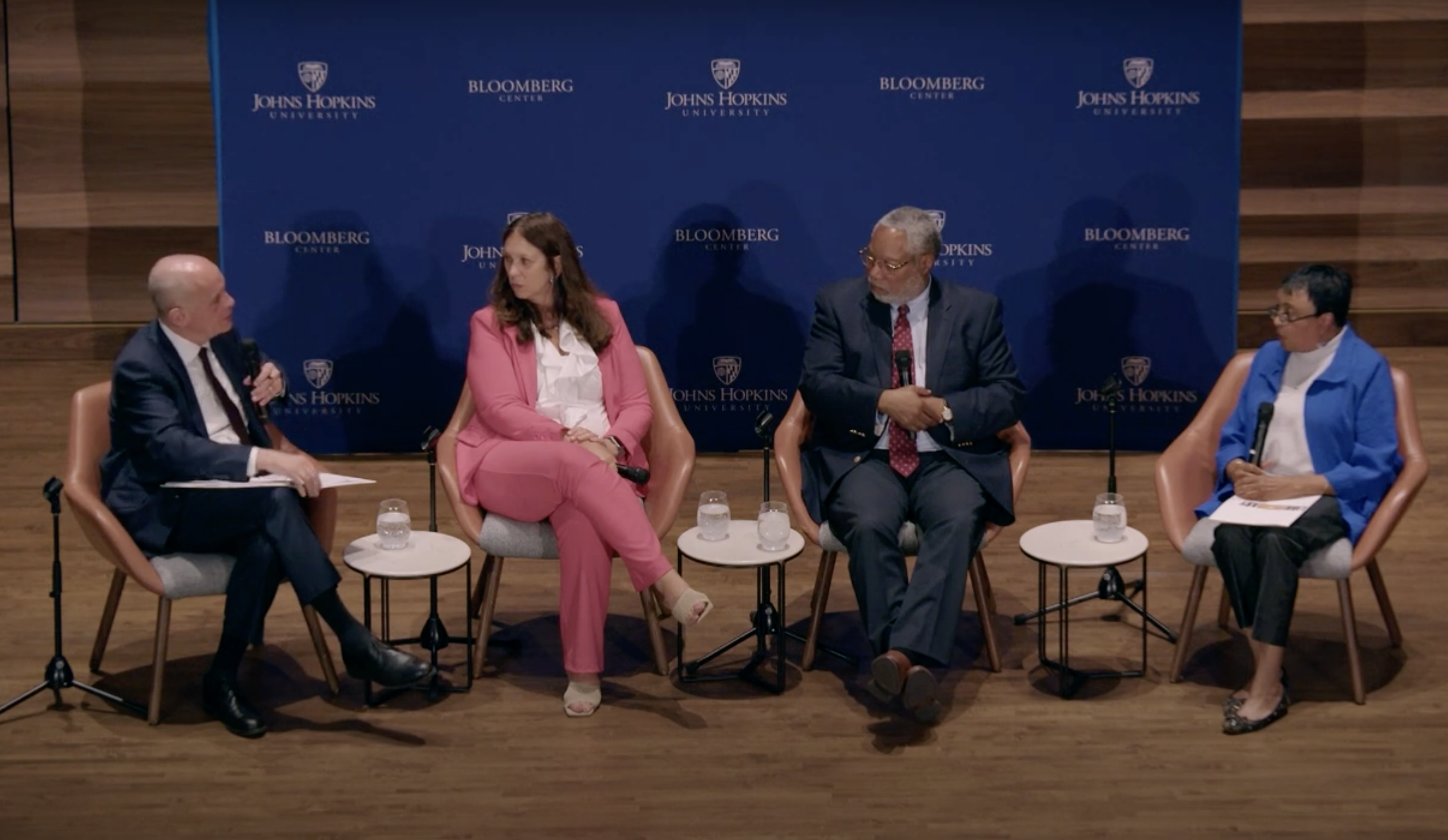 Four panelists seated on stage